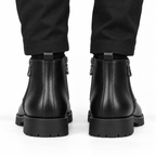 Back view of black leather ankle boots with pull tabs and chunky lug soles