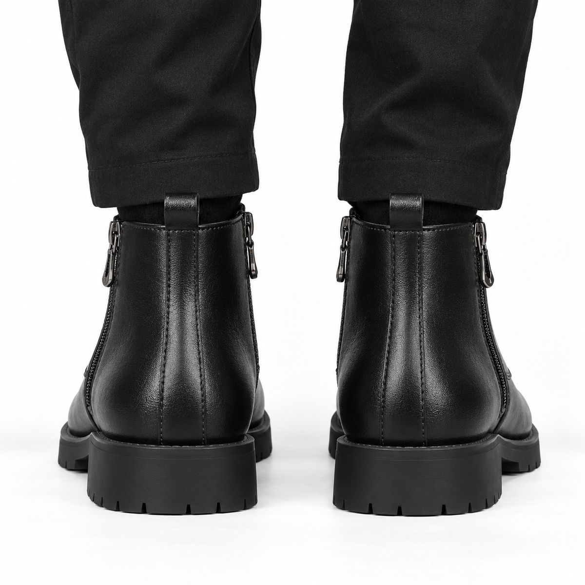 Back view of black leather ankle boots with pull tabs and chunky lug soles