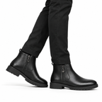 Side view of black leather ankle boots with side zipper and chunky rubber soles