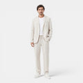 Man wearing a light beige suit on a white background