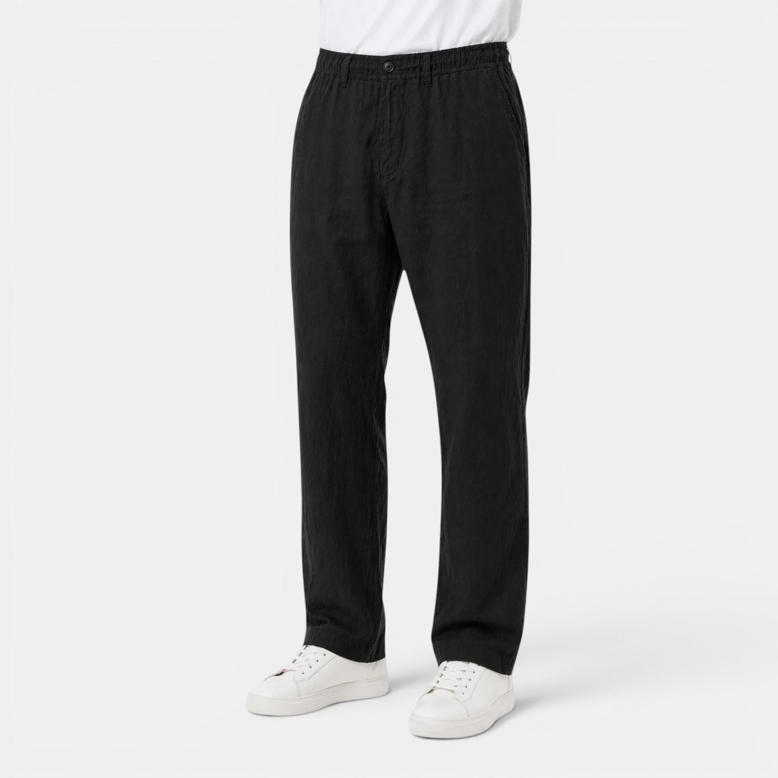 Person wearing black pants and white shoes on a white background