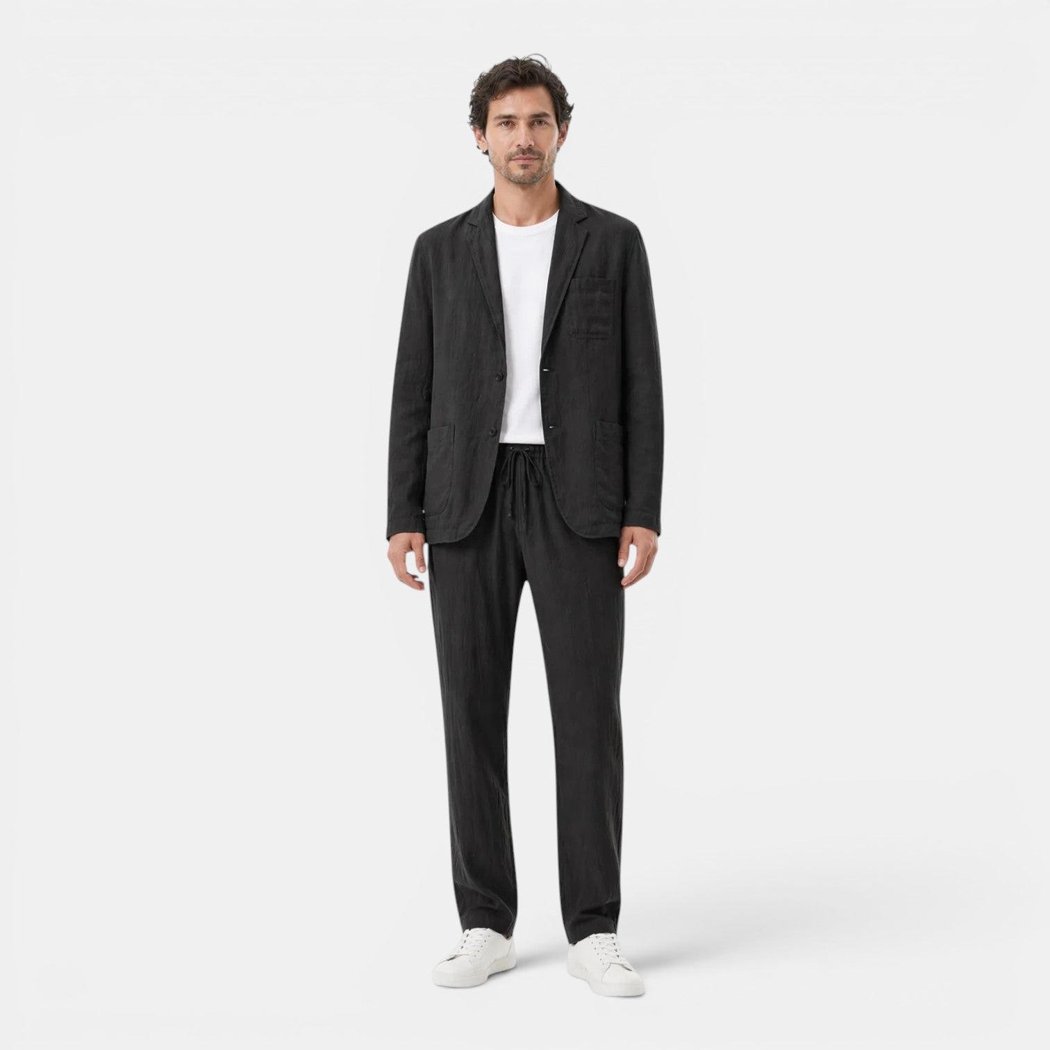 Man wearing a black suit with a white shirt on a white background