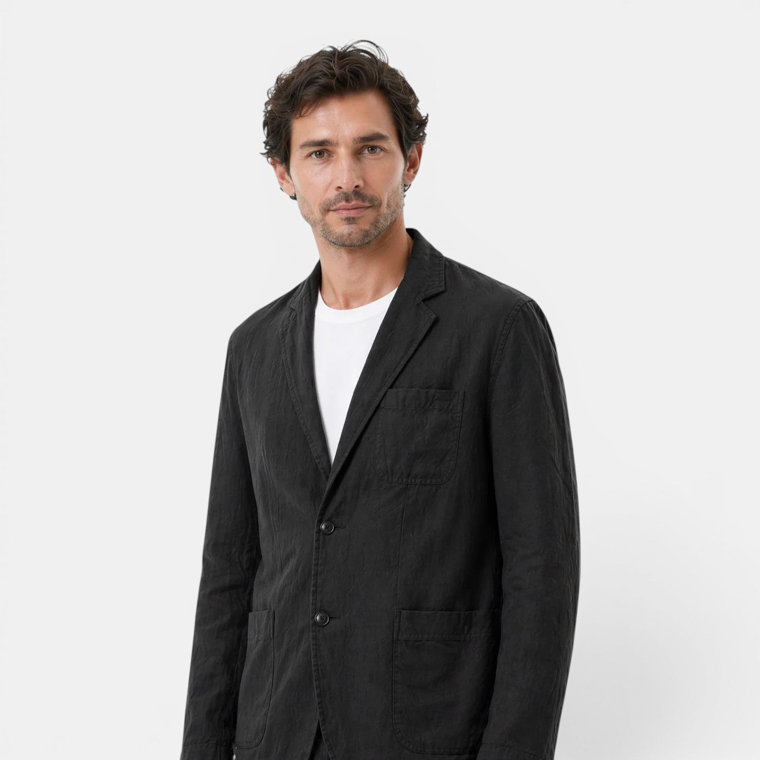 Man wearing a black jacket over a white shirt on a white background