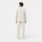 Person wearing a beige suit on a white background