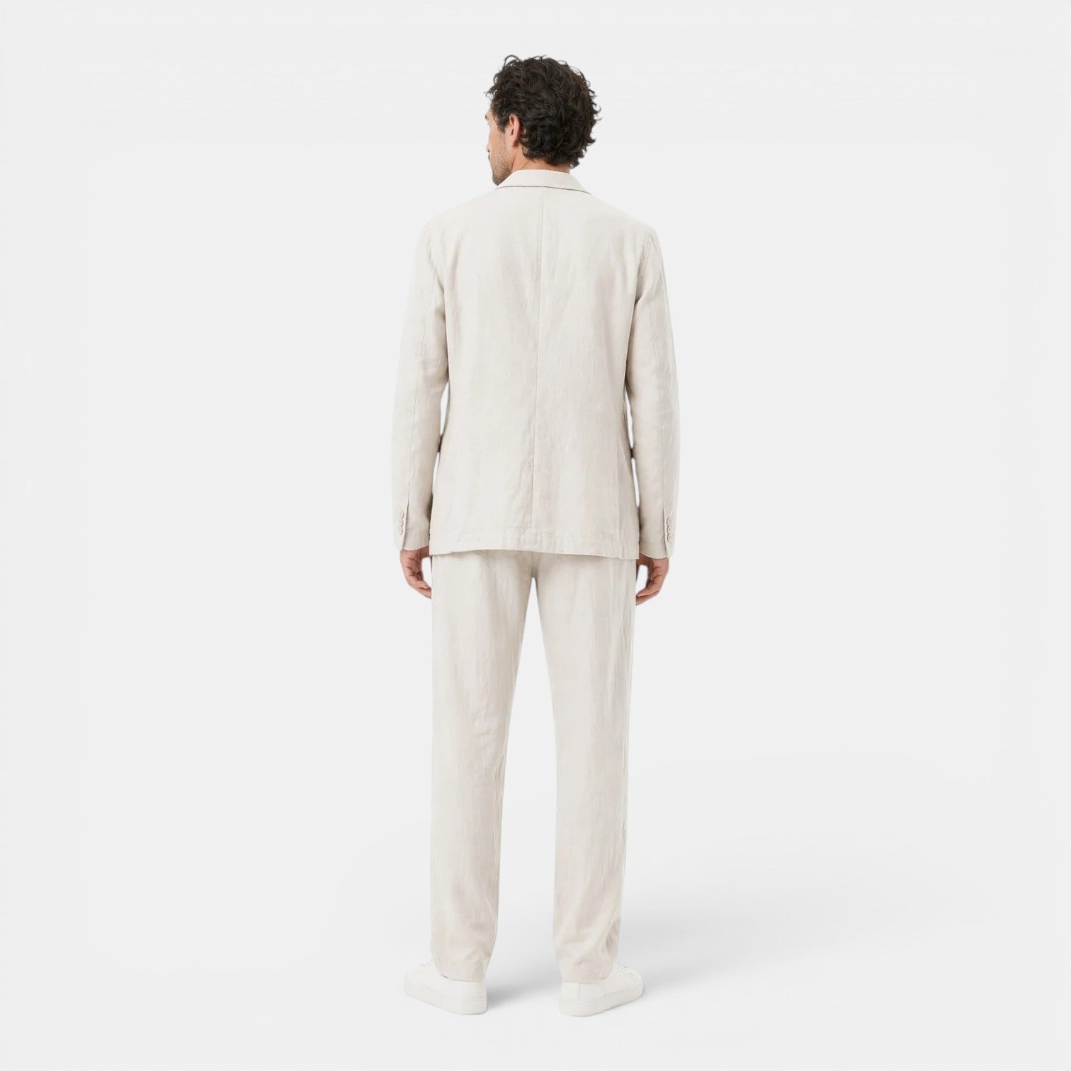 Person wearing a beige suit on a white background