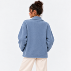 Back view of a woman wearing a light blue double-breasted knit blazer