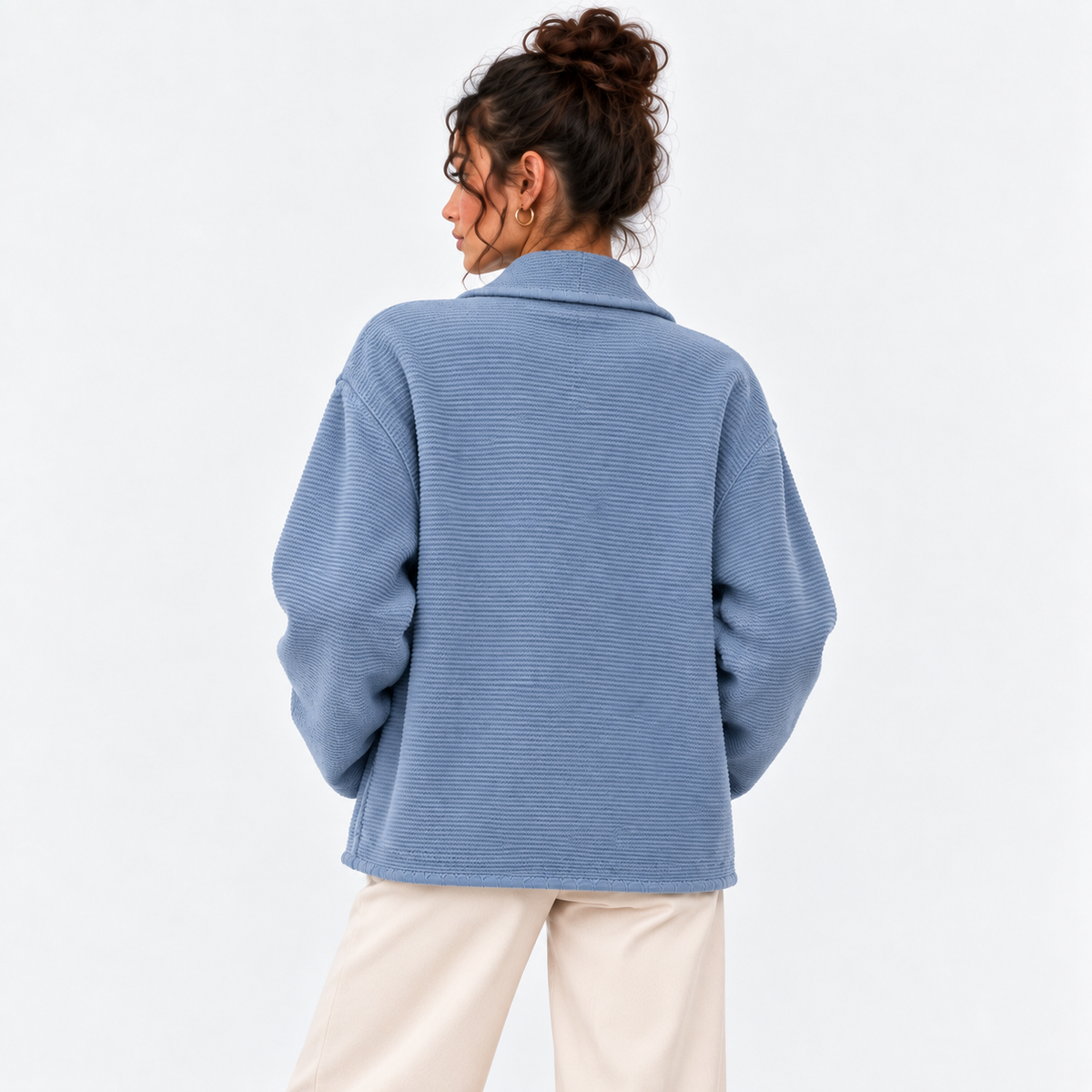 Back view of a woman wearing a light blue double-breasted knit blazer