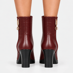 Back view of women's burgundy ankle boots with back seams and block heels