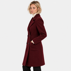 Side view of a woman wearing a burgundy double-breasted long coat