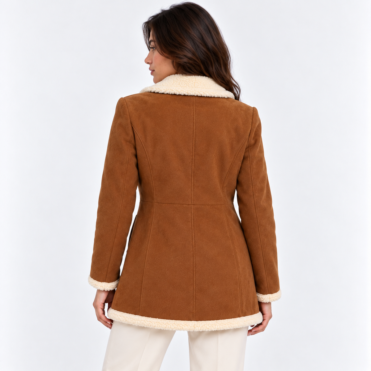 Back view of a woman wearing a brown shearling coat with cream faux fur lining