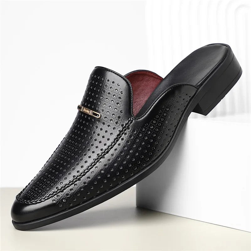 Black leather dress shoe with a textured design on a white background