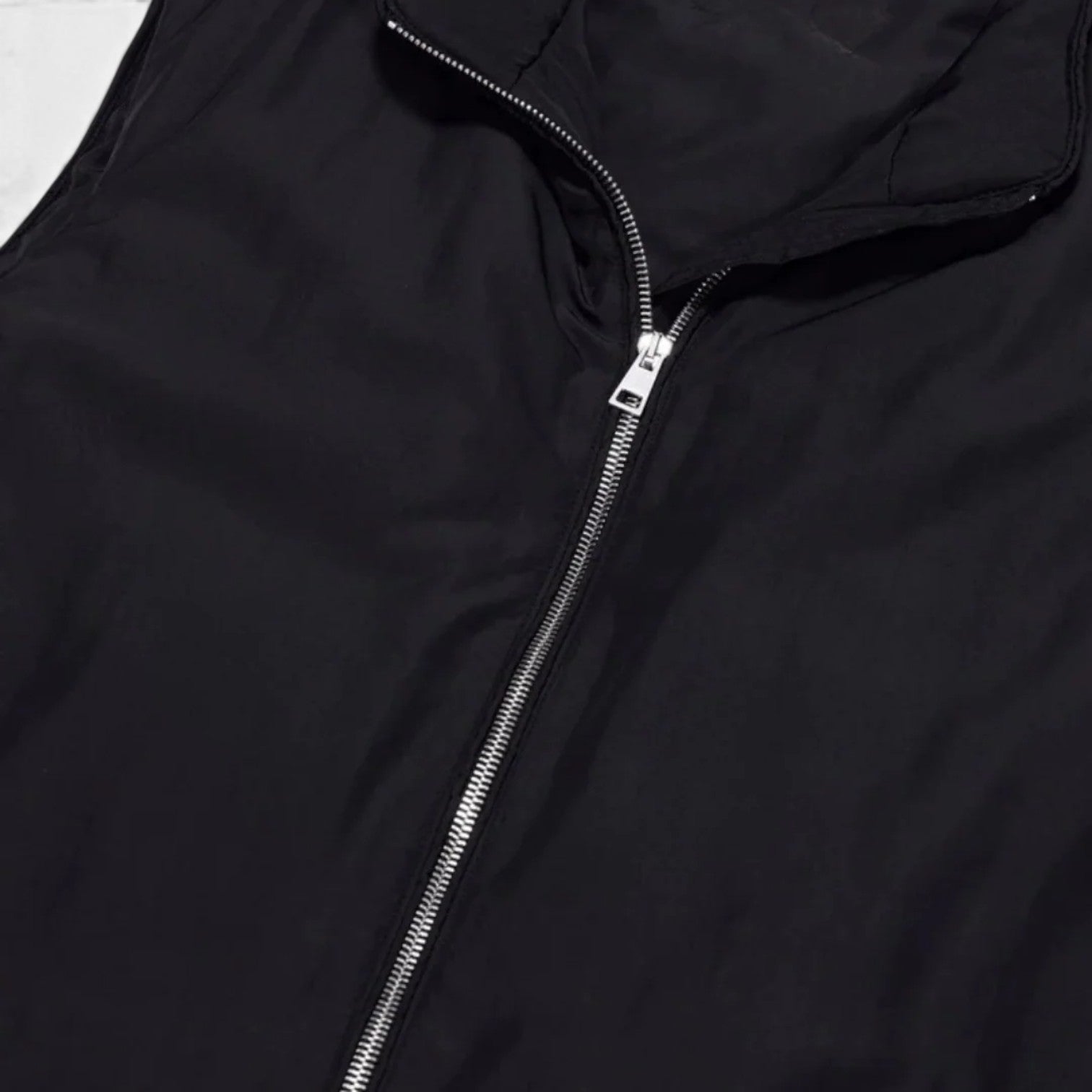 Close-up of a black jacket with a zipper on a white background