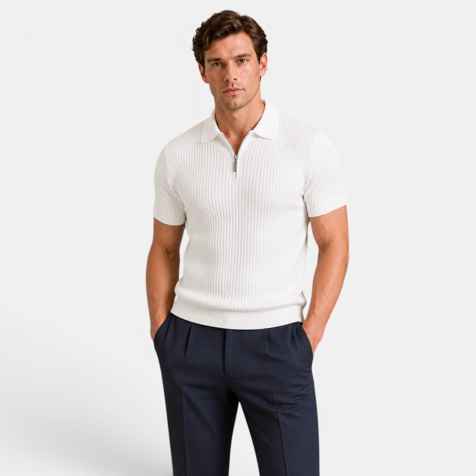 Man wearing a white ribbed knit polo shirt with navy trousers, standing against a light gray background.