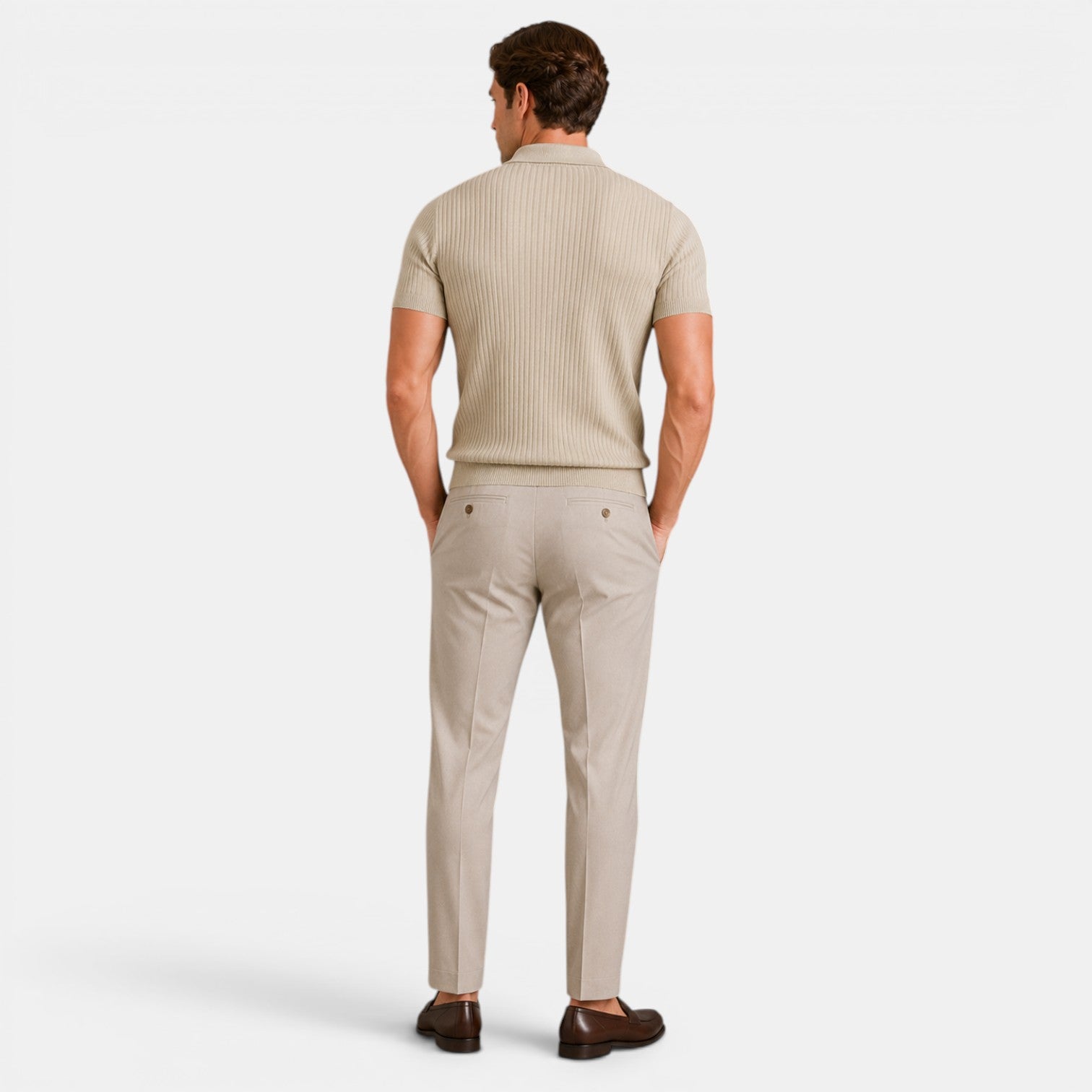 Back view of a man wearing a beige ribbed knit polo shirt with matching trousers and brown loafers.