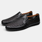 Pair of black perforated leather loafers with a slip-on design and breathable cutout pattern.