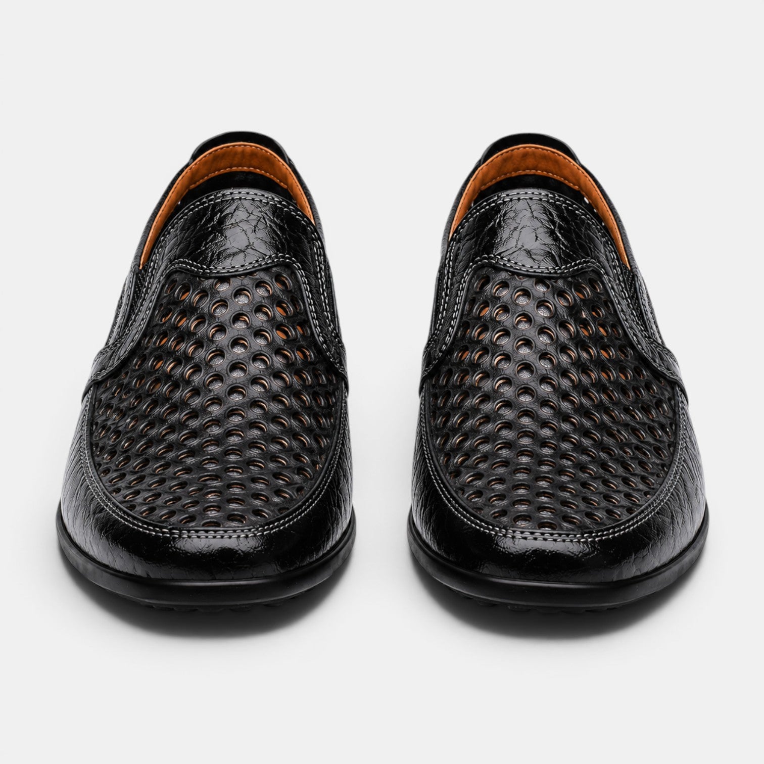 Front view of black perforated leather loafers with a breathable slip-on design.