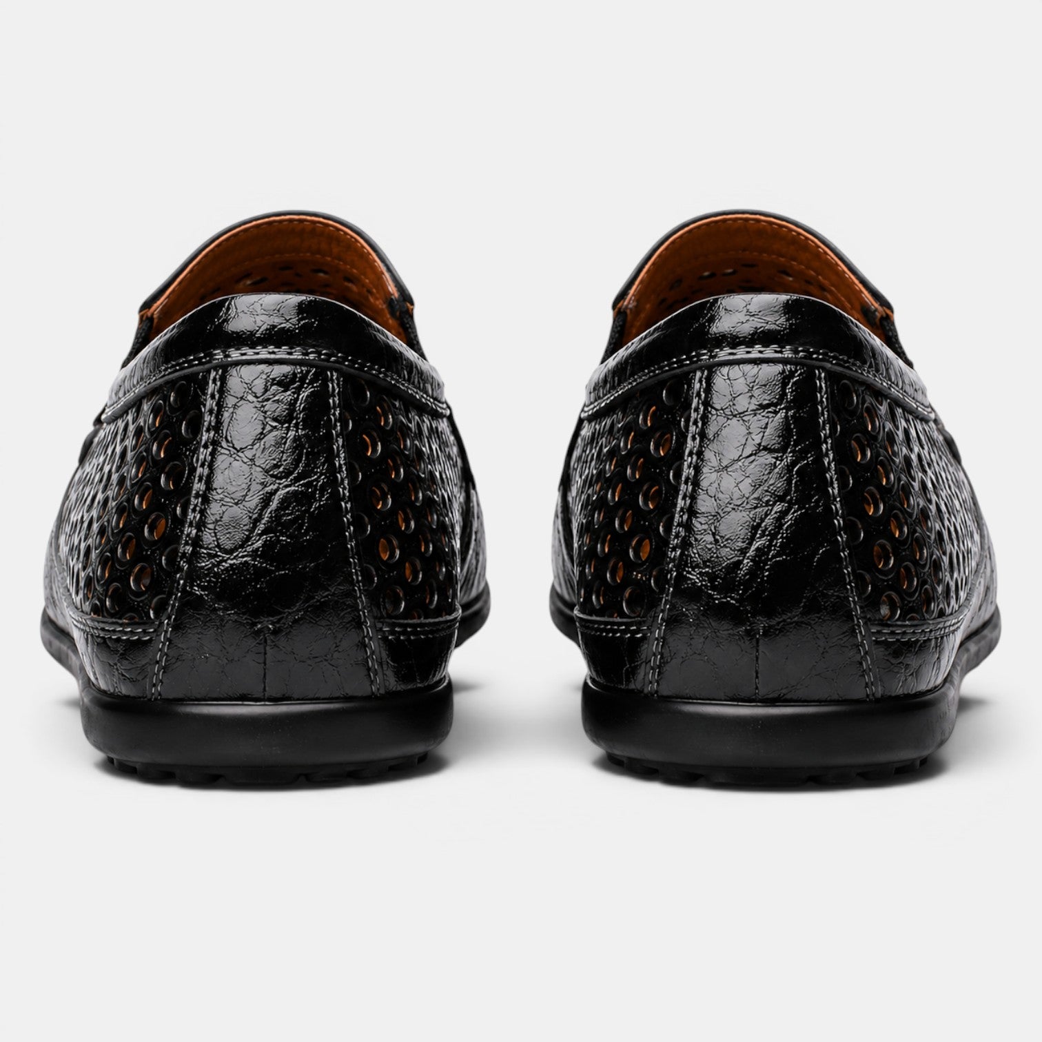 Back view of black perforated leather loafers with a breathable slip-on design.