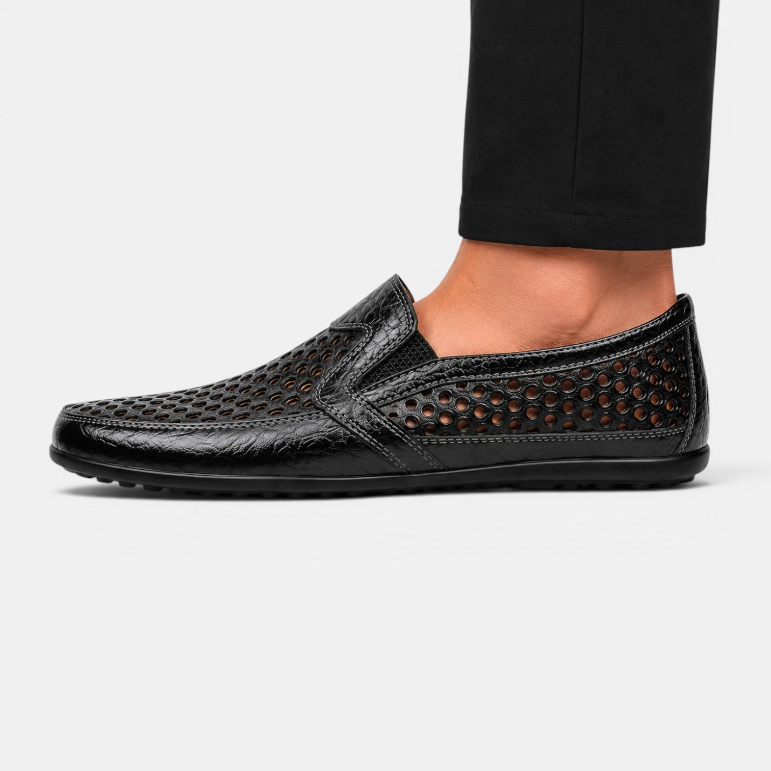 Side view of a black perforated leather loafer with a breathable slip-on design.