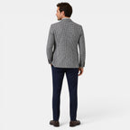 Back view of a young man wearing a checked blazer, navy trousers, and brown loafers.