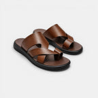 Pair of brown sandals with black soles on a light gray background