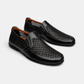 Black perforated leather slip-on loafers with breathable design.