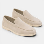 Pair of beige loafers on a light gray background