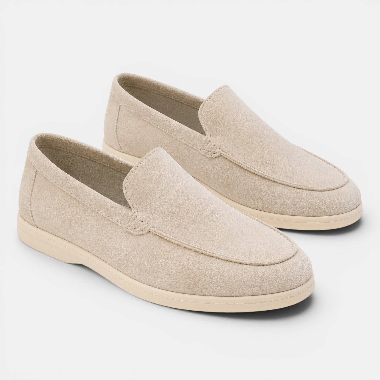 Pair of beige loafers on a light gray background