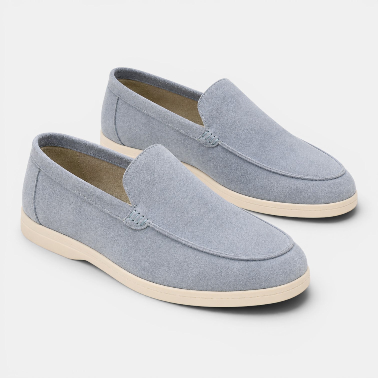 Pair of light blue loafers on a white background