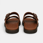 Pair of brown sandals with black soles on a white background
