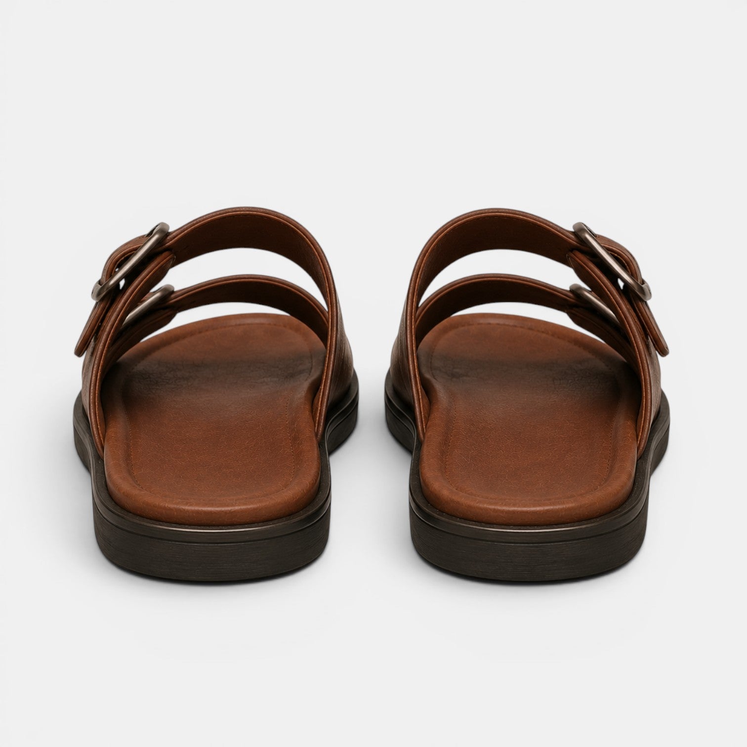 Pair of brown sandals with black soles on a white background