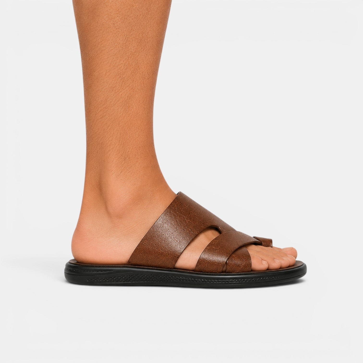 Brown sandal worn on a foot against a white background