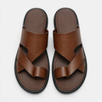 Pair of brown sandals with criss-cross straps on a white background