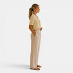 Woman wearing a beige blouse and pants on a white background