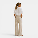 Woman wearing a white shirt and beige pants on a white background