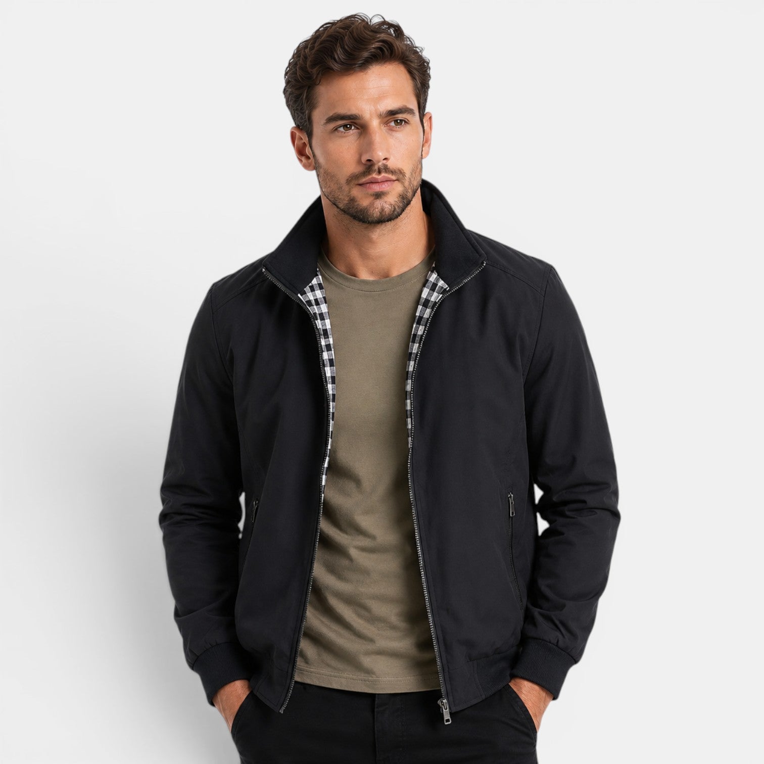 Man wearing a black jacket over a green shirt on a white background