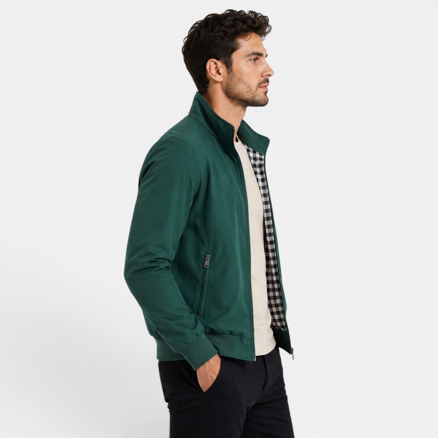 Man wearing a green jacket over a checkered shirt on a white background
