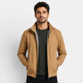 Man wearing a brown jacket over a black shirt with a white background