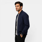 Man wearing a navy blue bomber jacket on a white background