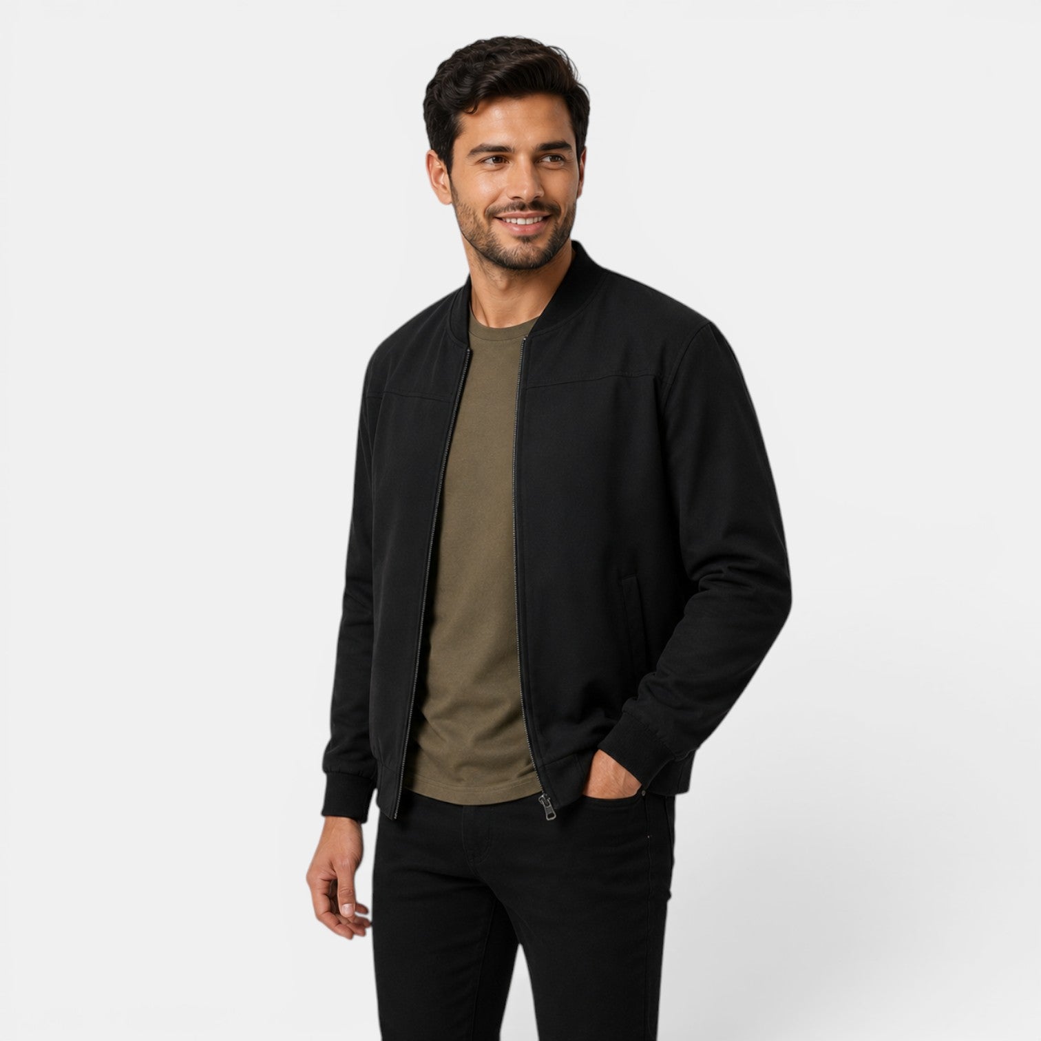 Man wearing a black bomber jacket over a green shirt on a white background