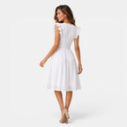 Woman wearing a white dress on a plain background