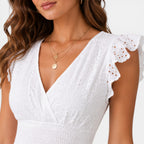 Woman wearing a white dress with lace sleeves on a white background