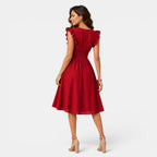 Woman wearing a red dress with ruffled sleeves on a white background