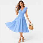 Woman wearing a light blue dress holding a basket with flowers on a white background