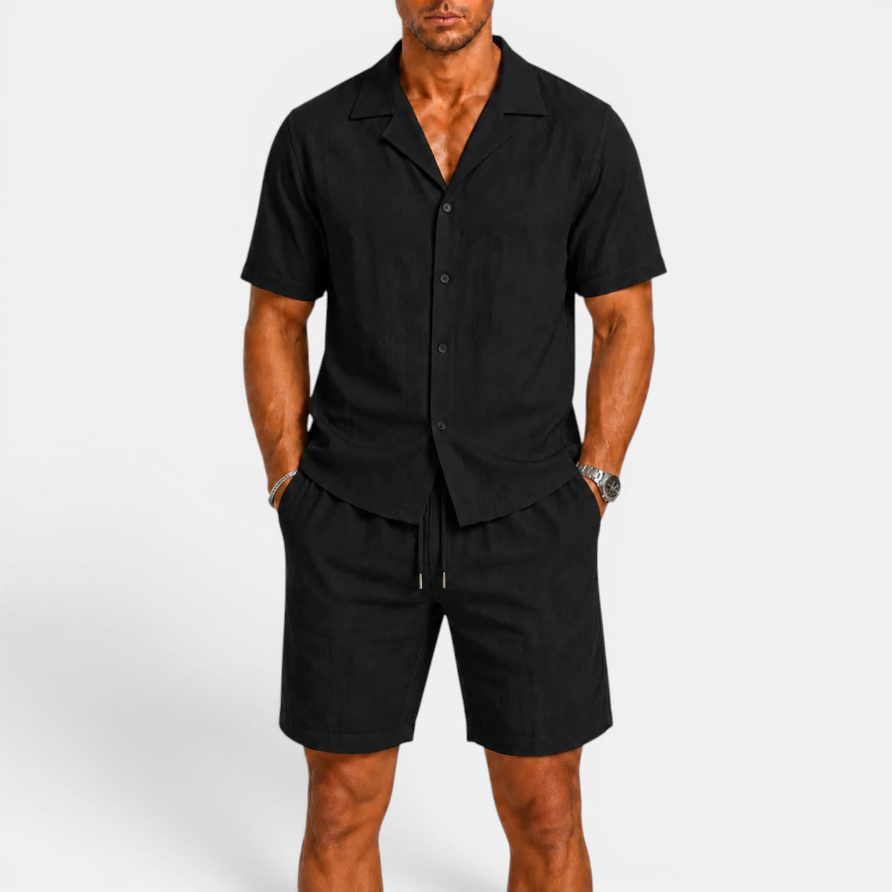 Man wearing a black button-up shirt and shorts set on a white background