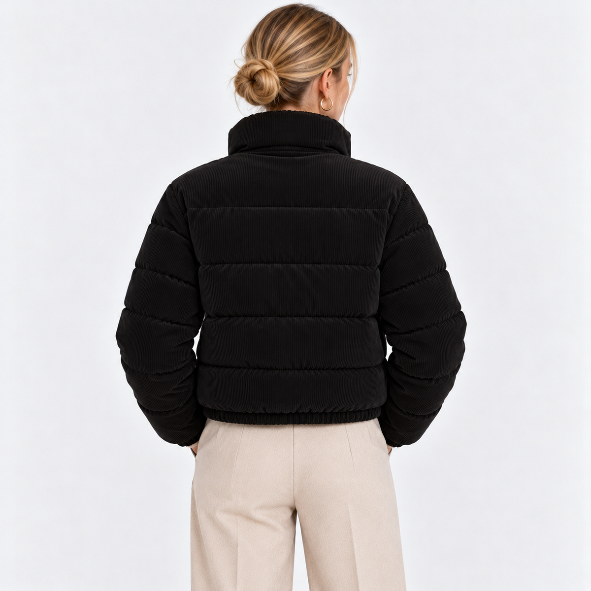 Back view of a woman wearing a black quilted puffer jacket with high collar