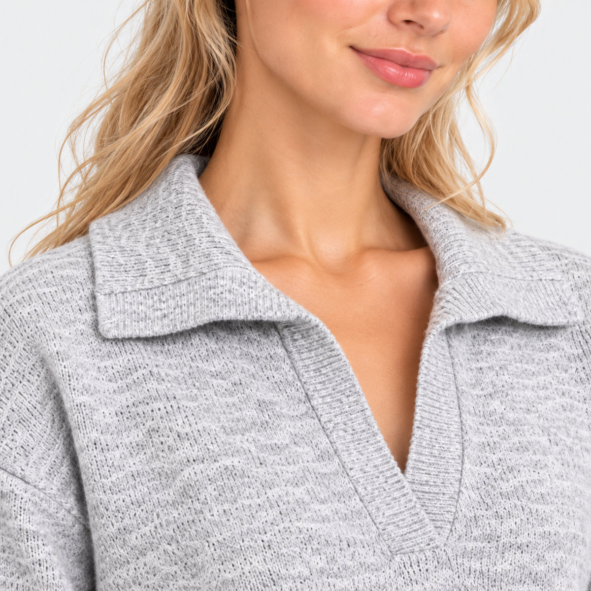 Close-up of women's light gray sweater with collared neckline and quarter-zip closure