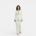 Woman wearing a white suit on a plain background