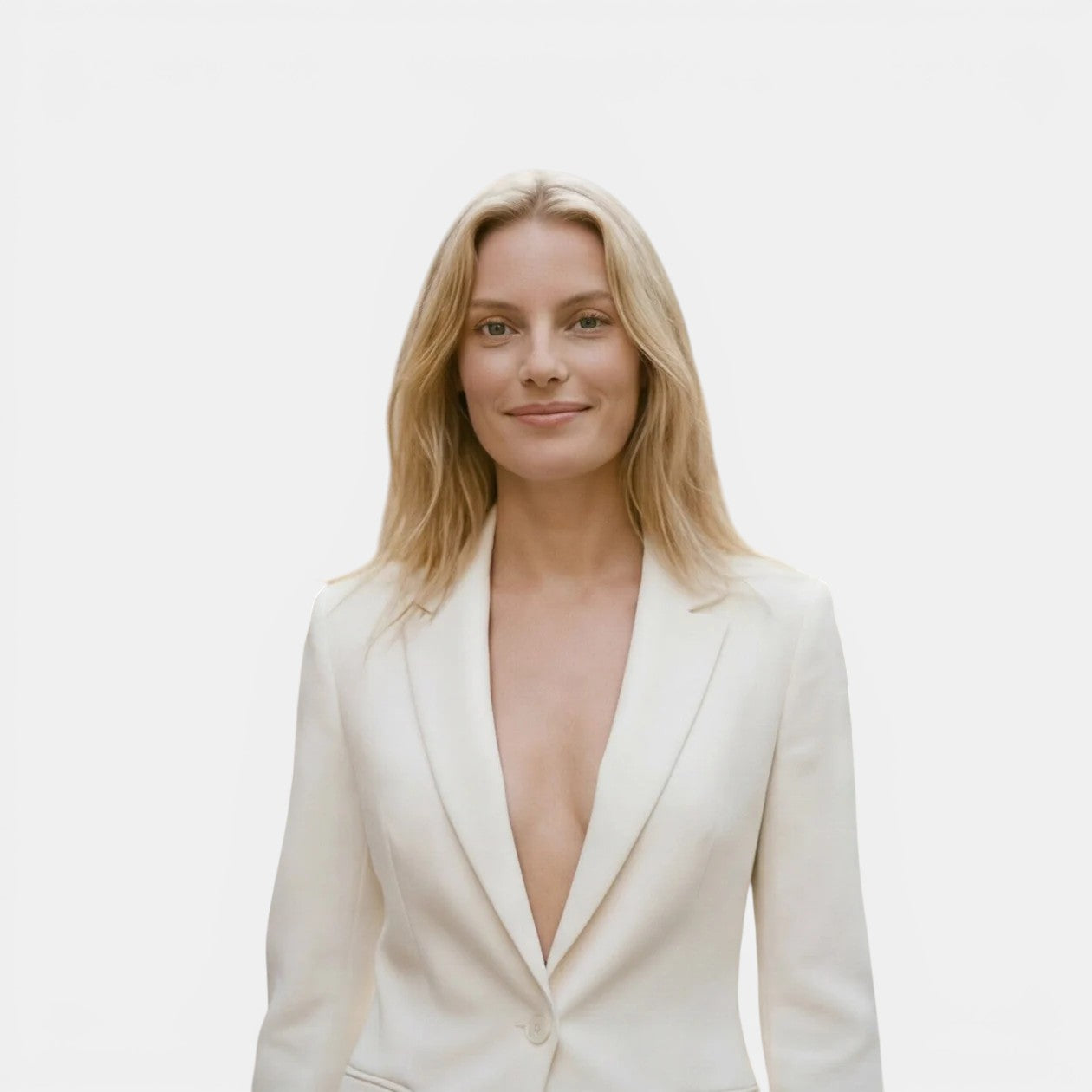 Woman wearing a white blazer with a plunging neckline on a plain background