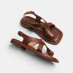 Pair of brown sandals on a light gray background