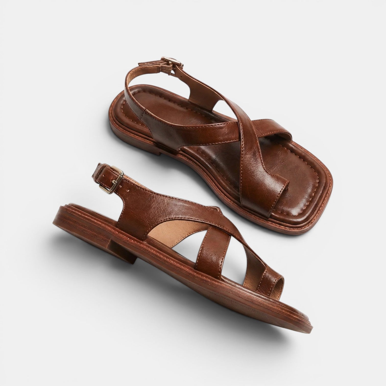 Pair of brown sandals on a light gray background